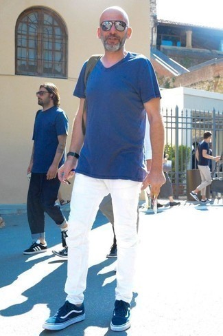Какие джинсы носить с темно-сине-белыми низкими кедами за 50 лет мужчине: Привлекательное сочетание синей футболки с v-образным вырезом и джинсов без сомнений будет обращать на себя взоры прекрасных женщин. Вкупе с этим ансамблем выигрышно выглядят темно-сине-белые низкие кеды.