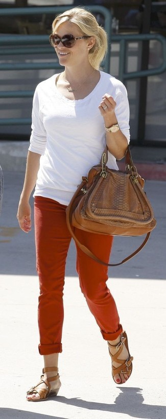 Как Reese Witherspoon носит Белая футболка с длинным рукавом, Красные брюки чинос, Коричневые кожаные гладиаторы, Коричневая кожаная сумка-саквояж