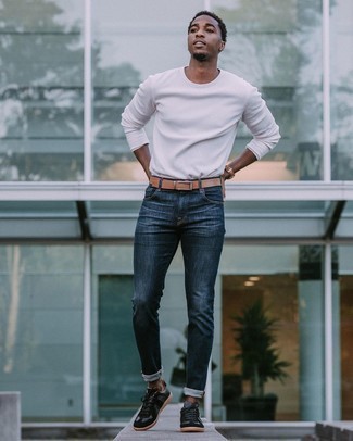 С чем носить темно-синие джинсы в 20 лет мужчине: Белая футболка с длинным рукавом и темно-синие джинсы — отличная идея для расслабленного, но стильного мужского лука. В сочетании с этим луком наиболее удачно смотрятся черные замшевые низкие кеды.