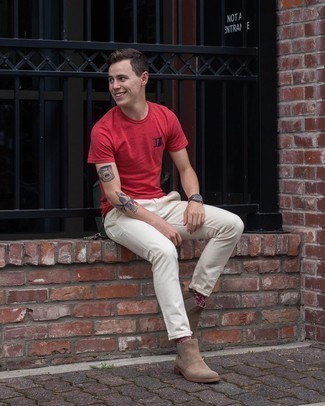С чем носить красную футболку в 20 лет мужчине: Можно с уверенностю сказать, что красная футболка смотрится прекрасно в тандеме с белыми брюками чинос. Весьма неплохо здесь смотрятся светло-коричневые замшевые ботинки челси.