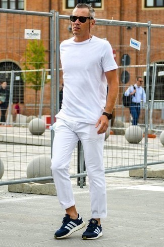 С чем носить футболку за 40 лет мужчине в жару: Футболка и белые брюки чинос — необходимые вещи в гардеробе модного современного мужчины. Что до обуви, дополни образ темно-сине-белыми кроссовками.