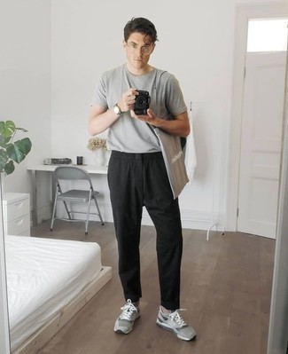 Модный лук: серая футболка с круглым вырезом, черные брюки чинос, серые кроссовки, серая большая сумка из плотной ткани с принтом