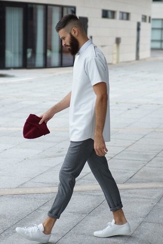Модный лук: белая футболка с круглым вырезом, серые брюки чинос, белые кожаные низкие кеды, темно-красная шапка