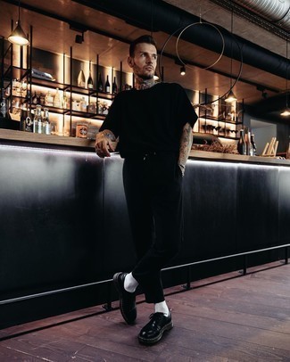 С чем носить туфли дерби в жару: Черная футболка с круглым вырезом и черные брюки чинос — необходимые вещи в гардеробе стильного джентльмена. И почему бы не привнести в повседневный образ немного изысканности с помощью туфель дерби?
