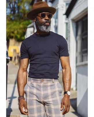 С чем носить коричневую шерстяную шляпу за 40 лет мужчине в стиле кэжуал: Если в одежде ты делаешь ставку на удобство и практичность, темно-синяя футболка с круглым вырезом и коричневая шерстяная шляпа — хороший выбор для модного мужского лука на каждый день.