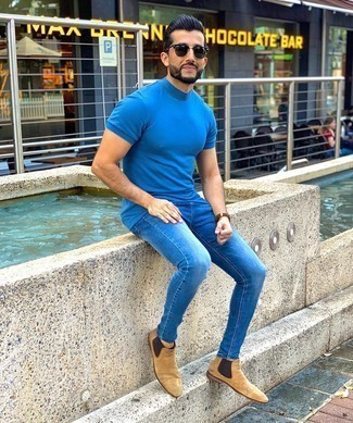 Как носить синие джинсы с светло-коричневыми замшевыми ботинками челси мужчине в теплую погоду: Бирюзовая футболка с круглым вырезом и синие джинсы без сомнений украсят твой гардероб. Думаешь сделать лук немного элегантнее? Тогда в качестве обуви к этому ансамблю, стоит обратить внимание на светло-коричневые замшевые ботинки челси.