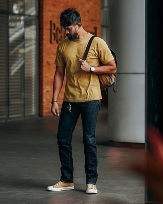 Какие джинсы носить с желтой футболкой с круглым вырезом мужчине лето в стиле кэжуал: Несмотря на то, что это достаточно не сложный образ, сочетание желтой футболки с круглым вырезом и джинсов приходится по душе стильным мужчинам, покоряя при этом дамские сердца. Такой лук несложно приспособить к повседневным реалиям, если завершить его табачными высокими кедами из плотной ткани. Переносить мучительную летнюю жару будет несомненно легче, если на тебе такое сочетание одежды.
