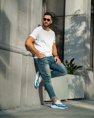 С чем носить синие рваные джинсы в 30 лет мужчине в спортивном стиле: Если ты наметил себе насыщенный день, сочетание белой футболки с круглым вырезом и синих рваных джинсов позволит создать практичный лук в расслабленном стиле. Пара бело-синих кроссовок идеально гармонирует с остальными вещами из лука.