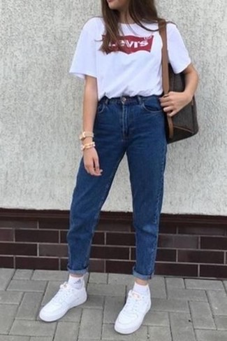 С чем носить синие джинсы в 20 лет женщине лето: Дуэт бело-красной футболки с круглым вырезом с принтом и синих джинсов поможет составить необычный наряд в расслабленном стиле. В паре с этим образом чудесно смотрятся белые кожаные низкие кеды. Подобное сочетание чудесно подходит для солнечной погоды.