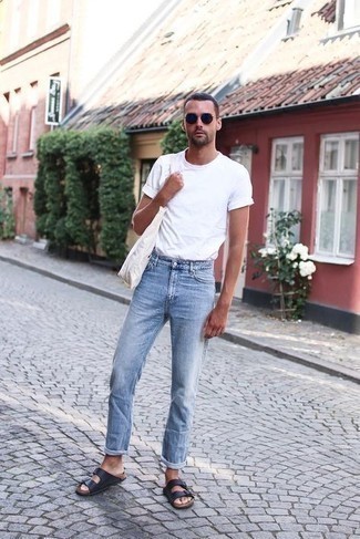 С чем носить голубые джинсы мужчине: Тандем белой футболки с круглым вырезом и голубых джинсов — хороший пример современного стиля в большом городе. Тебе нравятся незаурядные сочетания? Можешь закончить свой образ темно-синими кожаными сандалиями.