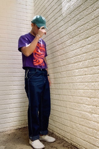 С чем носить слипоны в 30 лет мужчине в жару: Фиолетовая футболка с круглым вырезом с принтом и темно-синие джинсы — классная формула для создания привлекательного и практичного ансамбля. В тандеме с слипонами такой лук выглядит особенно удачно.