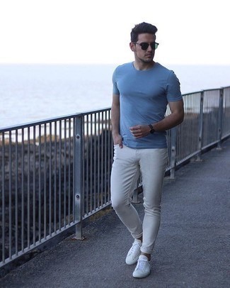 С чем носить бело-темно-синие низкие кеды из плотной ткани в 20 лет мужчине лето: Сочетание голубой футболки с круглым вырезом и белых зауженных джинсов - очень практично, и поэтому идеально для создания беззаботного повседневного  образа. Если ты предпочитаешь смелые решения в своих ансамблях, заверши этот бело-темно-синими низкими кедами из плотной ткани. Смело заявляем, подобный образ - просто огонь в жаркий солнечный день.