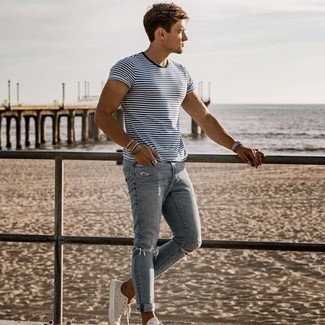 Как носить бело-темно-синюю футболку с круглым вырезом в горизонтальную полоску с бежевыми низкими кедами мужчине: Если в одежде ты делаешь ставку на комфорт и функциональность, бело-темно-синяя футболка с круглым вырезом в горизонтальную полоску и голубые рваные зауженные джинсы — превосходный выбор для привлекательного повседневного мужского ансамбля. Думаешь сделать образ немного элегантнее? Тогда в качестве дополнения к этому луку, стоит выбрать бежевые низкие кеды.