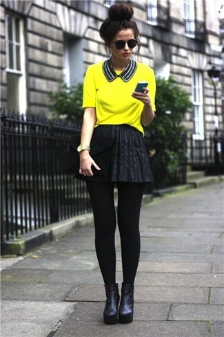 Какие короткие юбки-солнце носить с черными ботильонами в стиле смарт-кэжуал: Желтая футболка с круглым вырезом и короткая юбка-солнце — идеальный наряд для активного выходного дня. Черные ботильоны чудесно дополнят этот наряд.