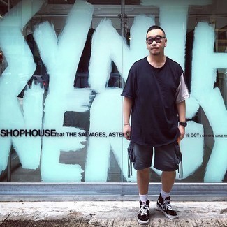 Модный мужской лук: темно-сине-белая футболка с круглым вырезом, темно-серые спортивные шорты, черно-белые высокие кеды из плотной ткани, серые солнцезащитные очки