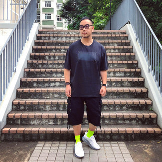 Модный мужской лук: темно-синяя футболка с круглым вырезом с принтом, черные шорты, белые кроссовки, серые солнцезащитные очки