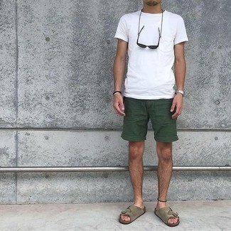 С чем носить темно-зеленые шорты мужчине: Как видишь, белая футболка с круглым вырезом смотрится выигрышно в тандеме с темно-зелеными шортами. Такой лук несложно адаптировать к повседневным реалиям, если завершить его коричневыми замшевыми сандалиями.