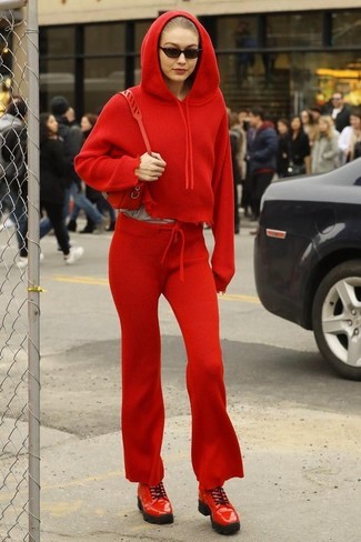 Как Gigi Hadid носит Красный худи, Красные спортивные штаны, Красные кожаные туфли дерби, Красная кожаная сумка через плечо
