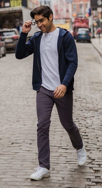 С чем носить пурпурные джинсы в 20 лет мужчине: Темно-синий худи и пурпурные джинсы надежно закрепились в гардеробе современных мужчин, помогая создавать запоминающиеся и стильные образы. Весьма неплохо здесь будут смотреться белые кожаные низкие кеды.