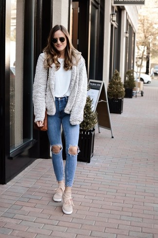 С чем носить серый свитер женщине в спортивном стиле: Если ты любишь выглядеть привлекательно и при этом чувствовать себя комфортно и уверенно, опробируй это сочетание серого свитера и синих рваных джинсов скинни. Весьма выигрышно здесь будут выглядеть бежевые замшевые слипоны.