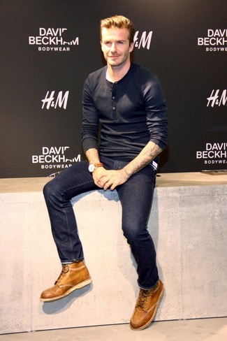 Как David Beckham носит Черная лонгслив с горловиной на пуговицах, Темно-синие джинсы, Светло-коричневые кожаные повседневные ботинки, Коричневые кожаные часы