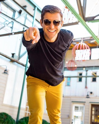 С чем носить желтые брюки мужчине лето в стиле смарт-кэжуал: Черная рубашка с длинным рукавом и желтые брюки — беспроигрышный выбор, если ты хочешь создать лёгкий, но в то же время стильный мужской ансамбль. Такое сочетание вещей точно поможет пережить мучительную летнюю жару.