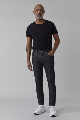Как одеваться мужчине за 40 в жару: Стильное сочетание черной футболки с круглым вырезом и темно-серых джинсов несомненно будет привлекать взоры прекрасного пола. И почему бы не разбавить образ с помощью белых кроссовок?