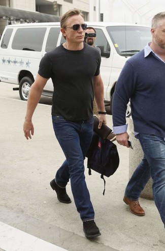 Как Daniel Craig носит Черная футболка с круглым вырезом, Темно-синие джинсы, Черные замшевые ботинки дезерты