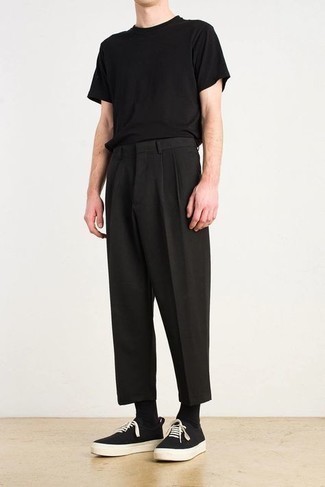 Модный лук: черная футболка с круглым вырезом, черные брюки чинос, черно-белые низкие кеды из плотной ткани, черные носки