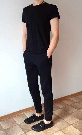 Модный лук: черная футболка с круглым вырезом, черные спортивные штаны, черные низкие кеды из плотной ткани