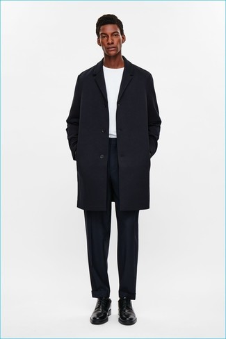 Модный лук: черное длинное пальто, белая футболка с круглым вырезом, темно-синие классические брюки, черные кожаные туфли дерби