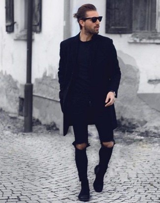 Как носить черные зауженные джинсы с черными замшевыми ботинками челси мужчине в прохладную погоду в стиле кэжуал: Черное длинное пальто и черные зауженные джинсы прочно обосновались в гардеробе многих парней, позволяя создавать незаезженные и стильные образы. В сочетании с черными замшевыми ботинками челси такой лук выглядит особенно гармонично.