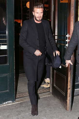 Как David Beckham носит Черное длинное пальто, Черный свитер с круглым вырезом, Черные классические брюки, Темно-коричневые замшевые ботинки челси