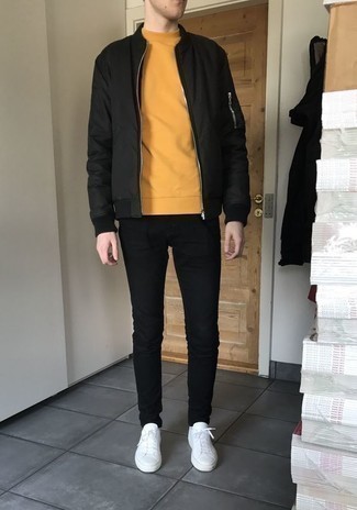 С чем носить желтый свитшот в 20 лет мужчине в теплую погоду: Желтый свитшот и черные джинсы — отличный вариант, если ты ищешь простой, но в то же время стильный мужской лук. В сочетании с этим образом органично смотрятся белые кожаные низкие кеды.