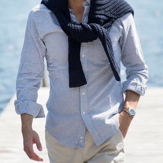 Модный лук: черный вязаный свитер, бело-синяя рубашка с длинным рукавом в вертикальную полоску, бежевые брюки чинос