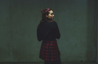 Модный лук: черный вязаный свитер, красная короткая юбка-солнце в шотландскую клетку