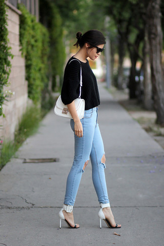 С чем носить голубые рваные джинсы женщине: Если ты ценишь комфорт и практичность, черный короткий свитер и голубые рваные джинсы — замечательный вариант для привлекательного повседневного ансамбля. В сочетании с этим образом наиболее удачно будут смотреться бело-черные кожаные босоножки на каблуке.