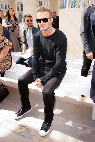 Как David Beckham носит Черный свитер с круглым вырезом, Черные брюки чинос, Черно-белые низкие кеды