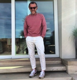 С чем носить кроссовки за 50 лет мужчине: Ярко-розовый свитшот будет смотреться выигрышно в тандеме с белыми брюками чинос. Ты сможешь легко адаптировать такой лук к повседневным реалиям, надев кроссовками.